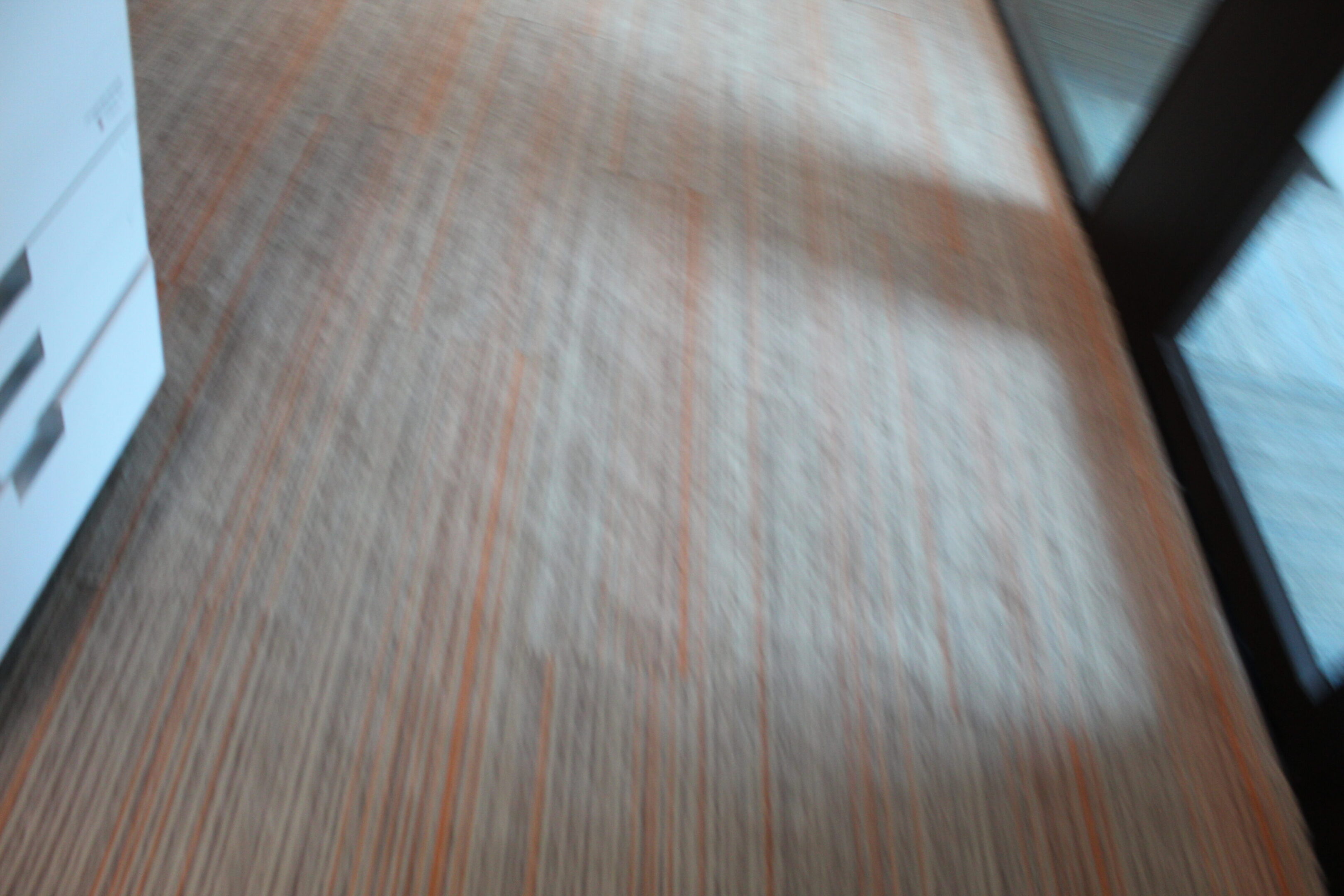 Blurred image of a wooden surface with light reflections.