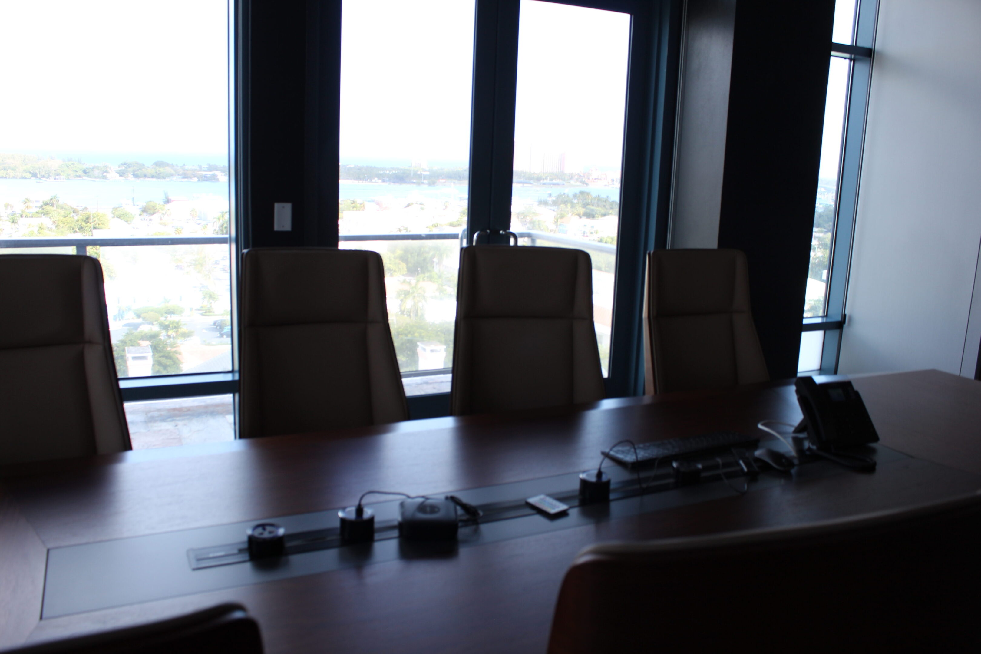 Empty conference room with chairs and a long table near large windows.