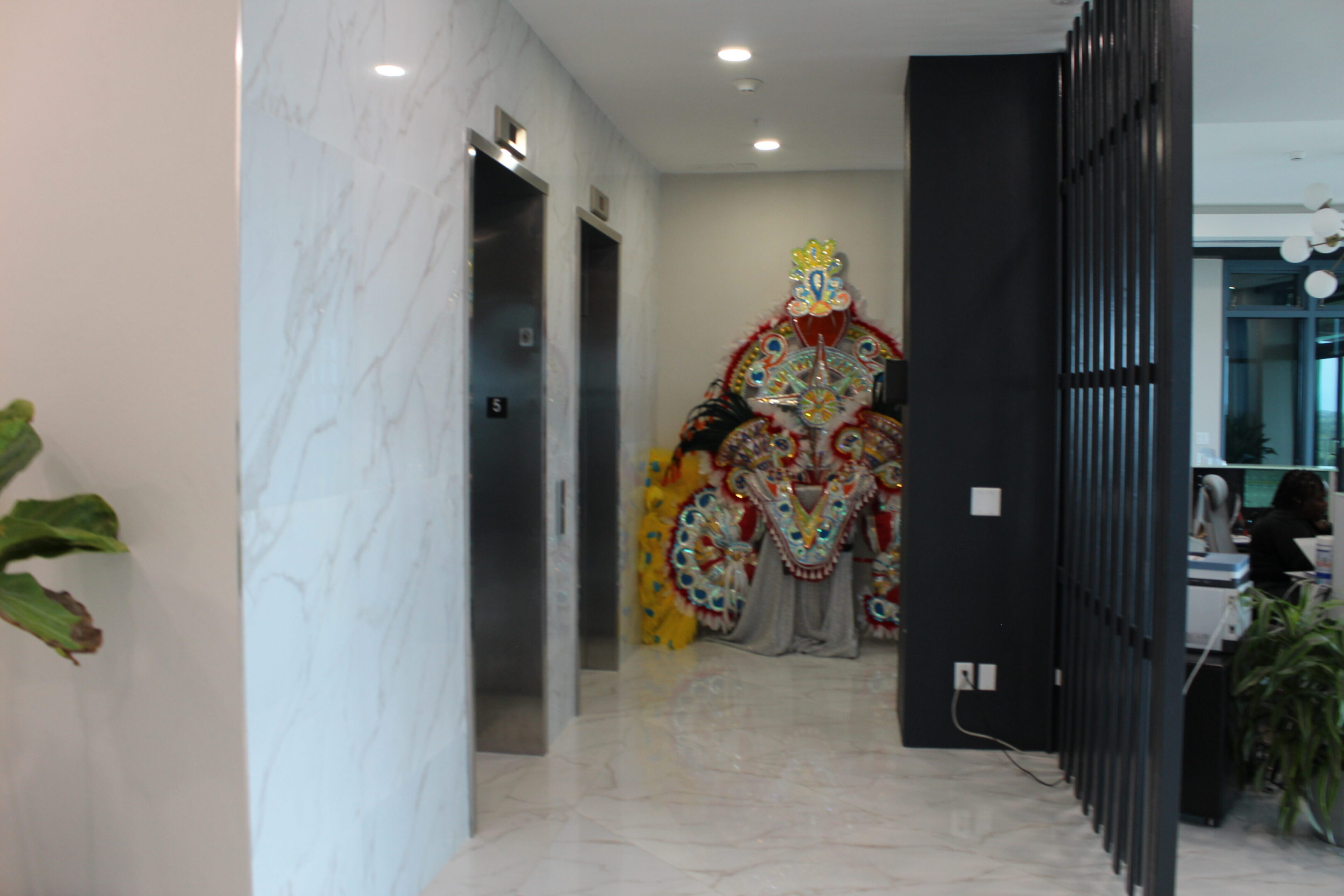 Modern lobby with elevators and colorful mural on the wall.