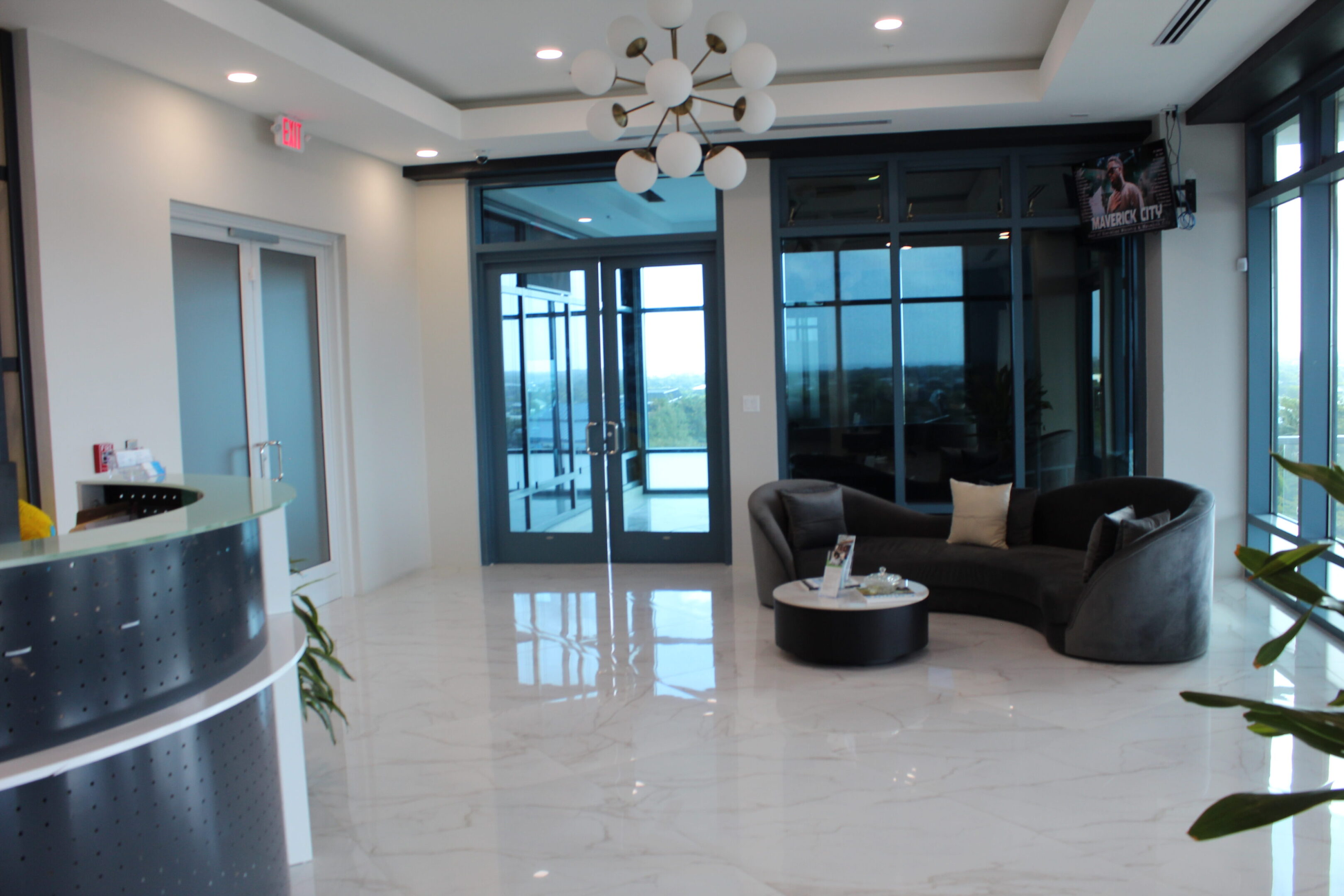 Modern living room with marble floors and black furniture.