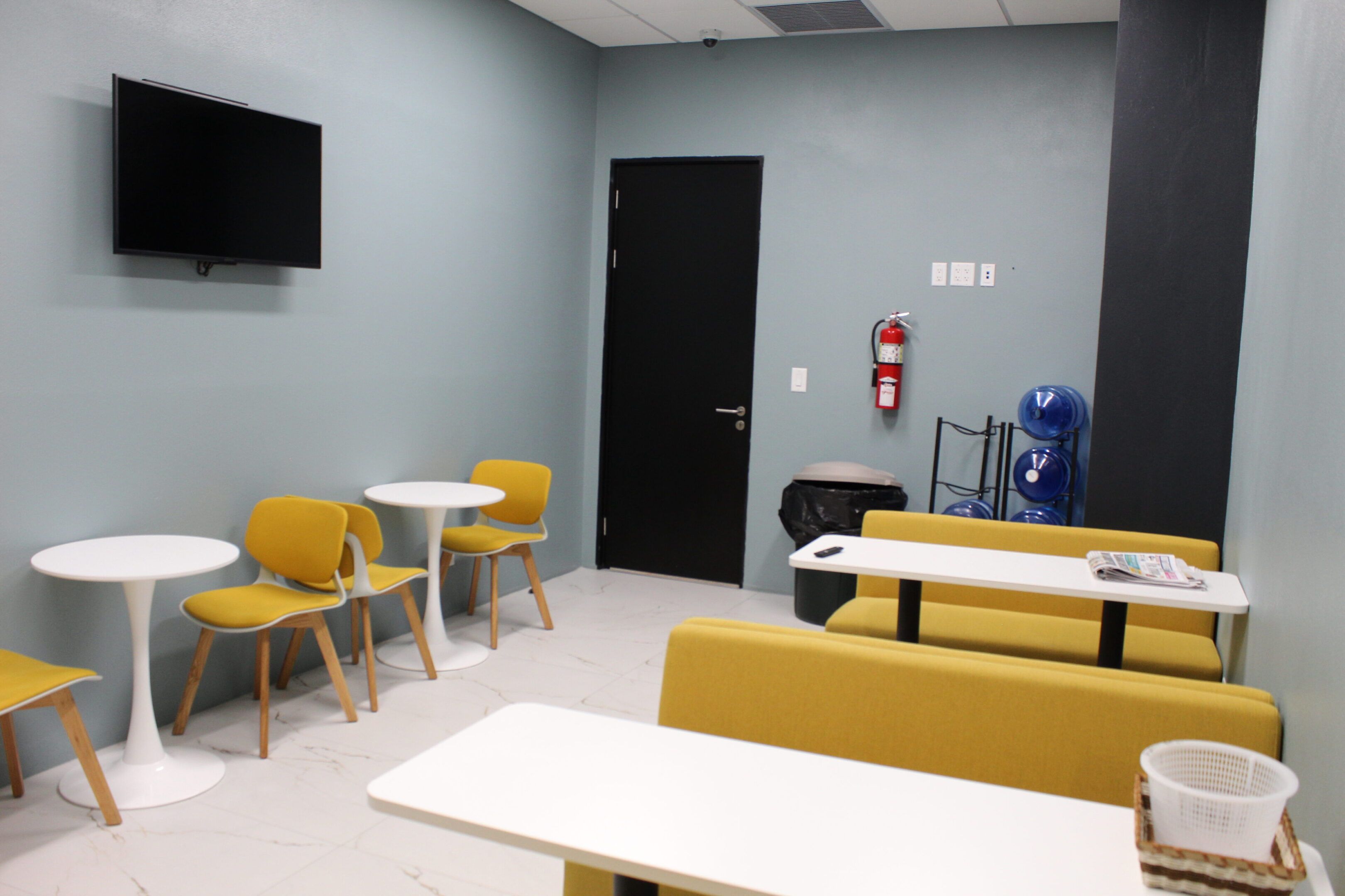 Modern waiting area with yellow chairs and tables.