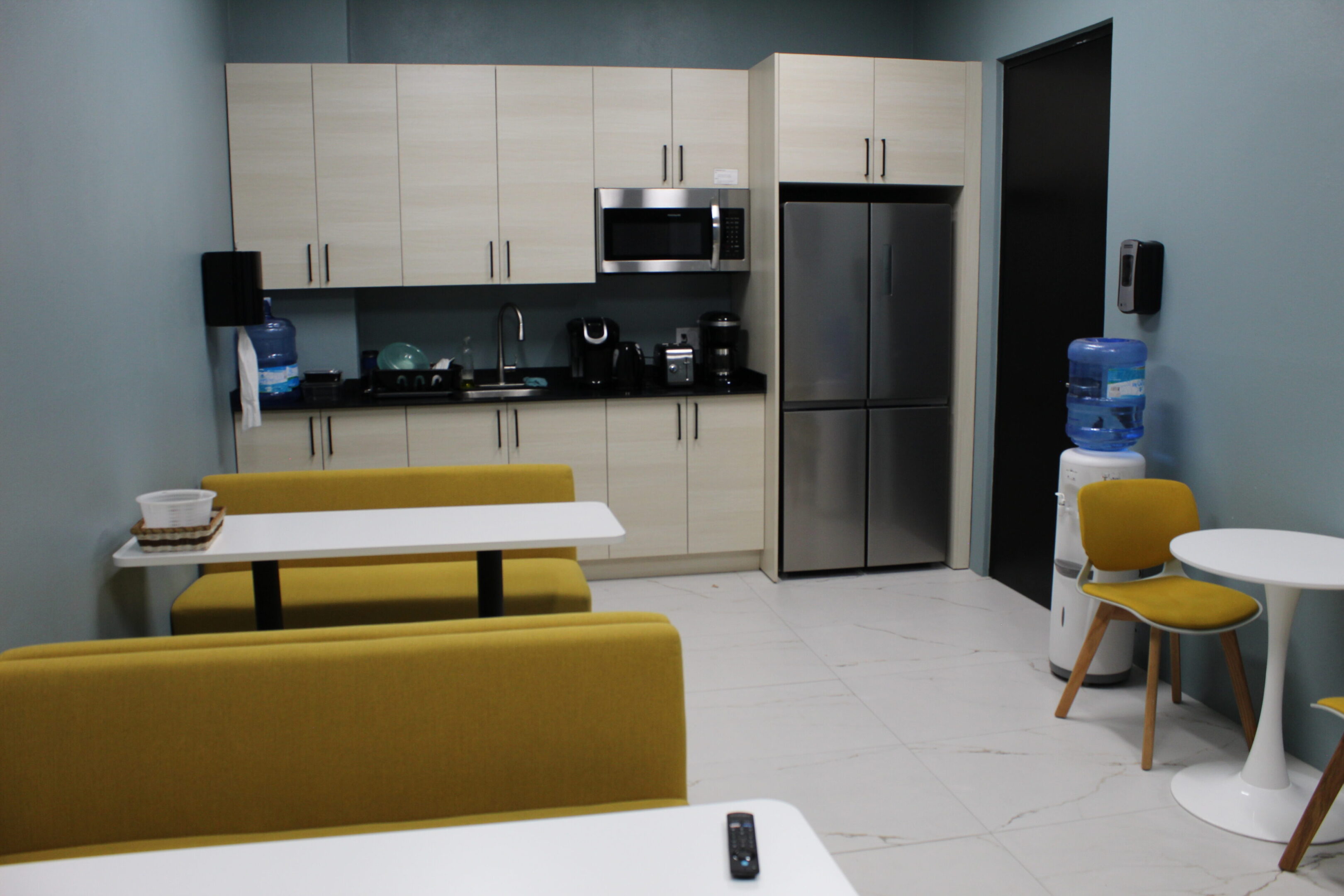 Modern kitchen with stainless steel appliances and yellow seating.