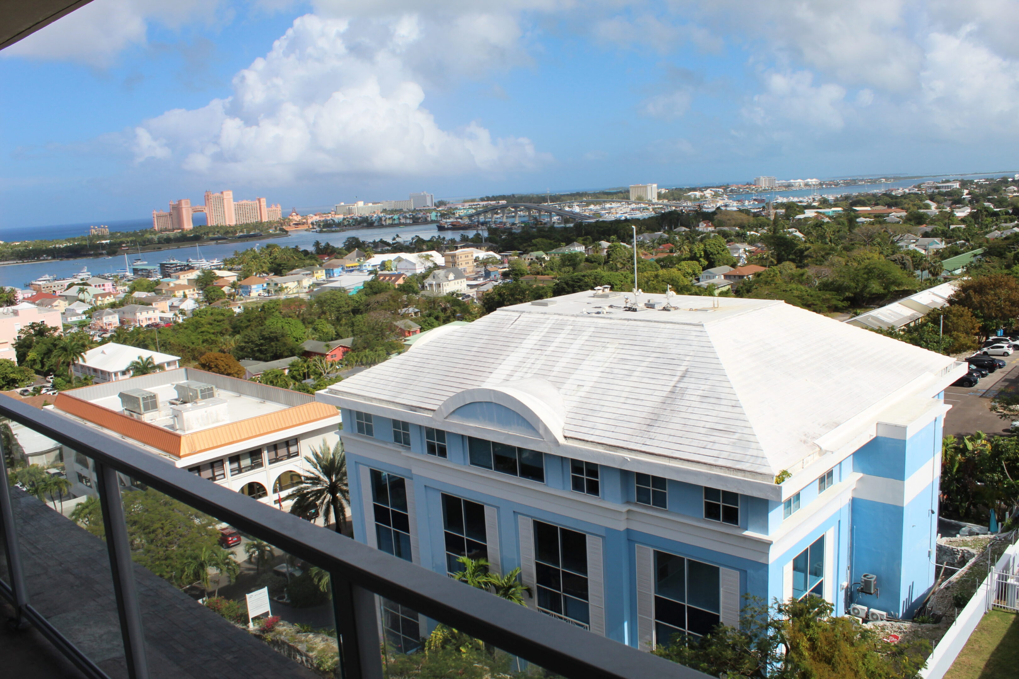 View of a white building with a cityscape and blue sky background.