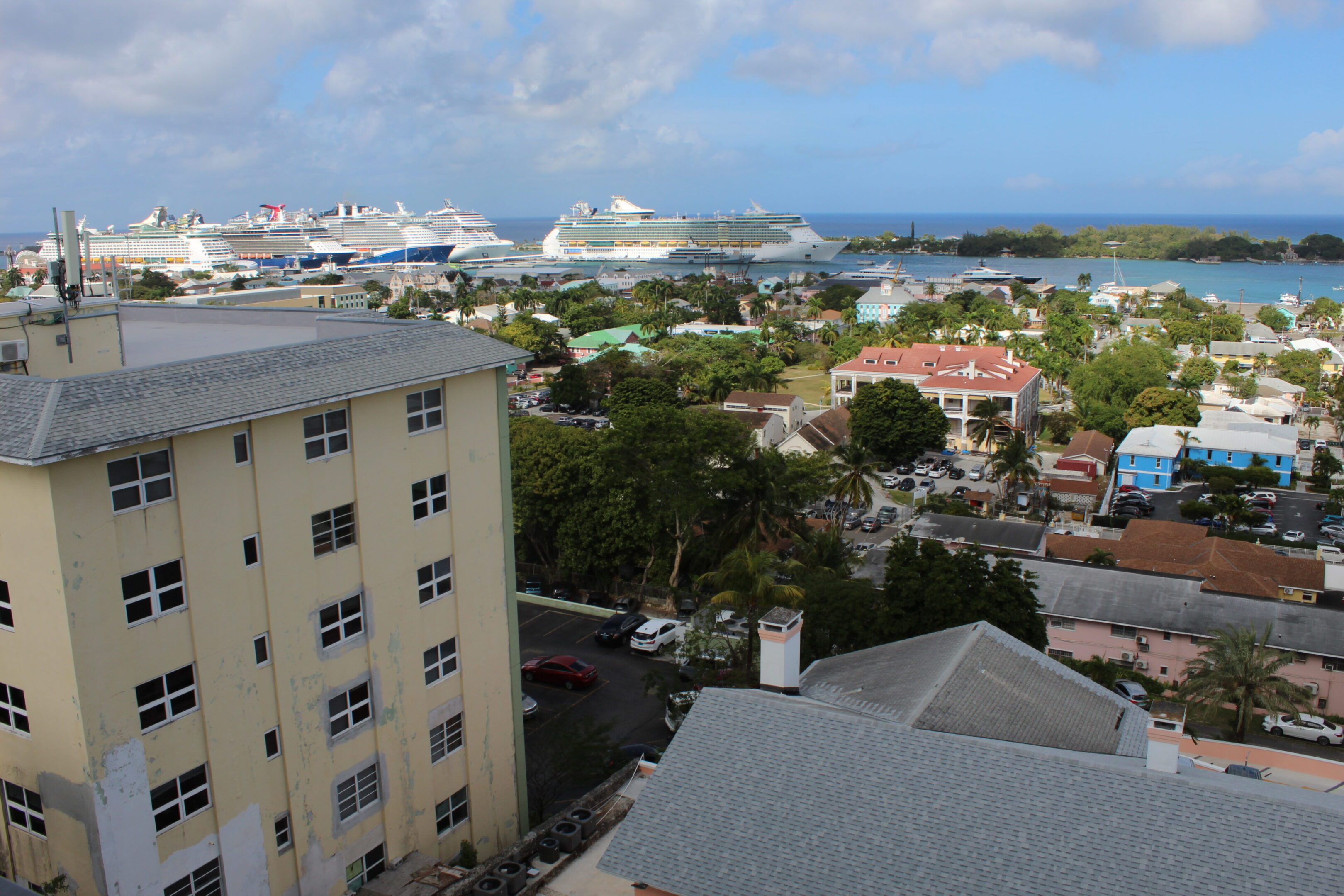 View of a coastal town with buildings and cruise ships in the harbor.