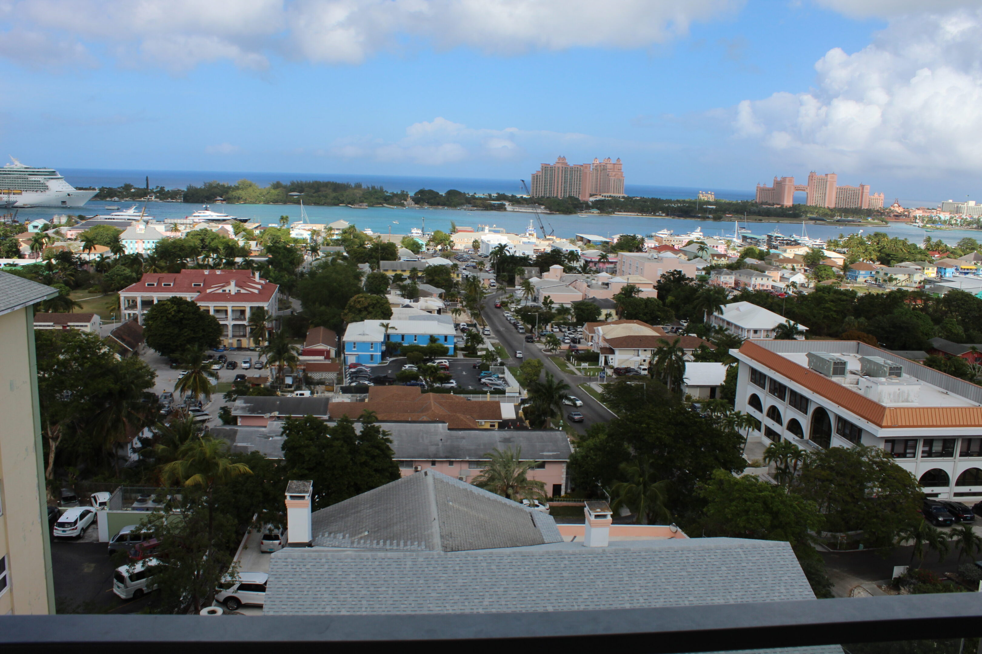 Scenic view of a coastal town with beaches and a distant resort under a blue sky.
